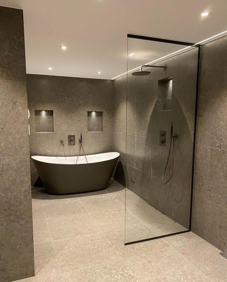 Detalj: glasad walk-in-dusch och svart badkar i mörk sten, Badrumshantverkaren i Göteborg