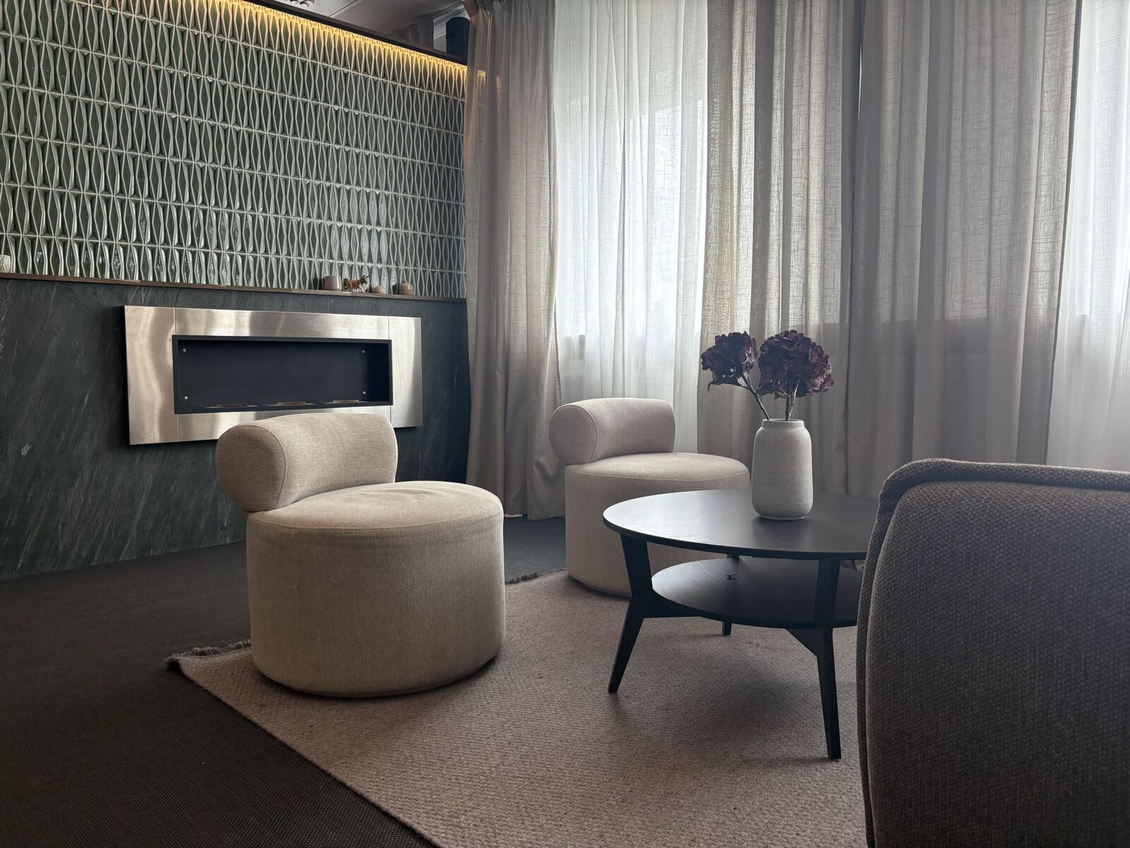 Loungen i Badrumshantverkarens showroom i Göteborg, med öppen spis och dämpat stämningsljus